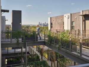 Modern apartment complex walkways with metal railings green planters and blurred figures city
