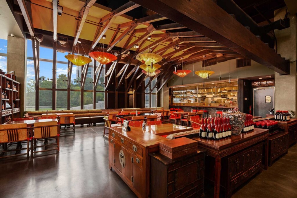 Asian restaurant interior with exposed wooden beams, umbrella pendant lights, and traditional