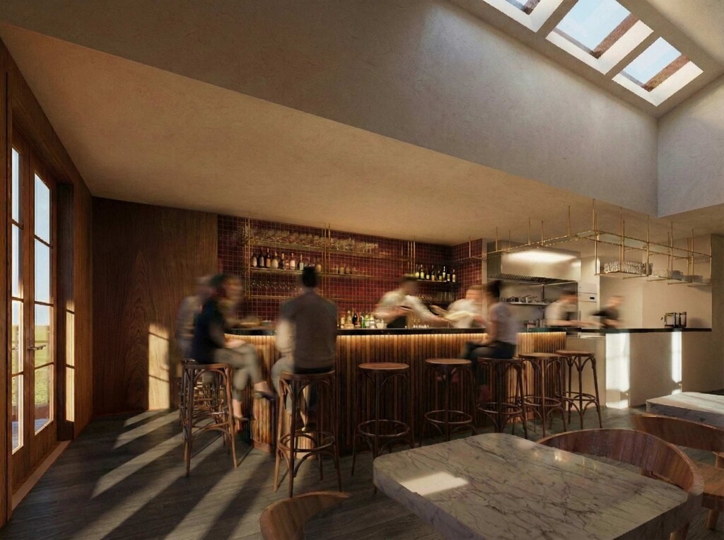 Interior bar area with wooden counter seating skylights and blurred figures in warm toned space